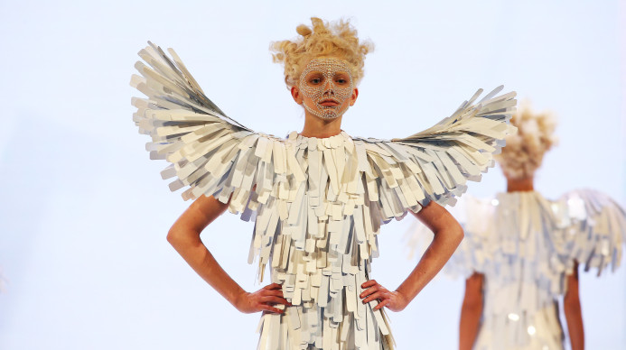 Woman designed to look like a bird with hair, makeup, and clothes adorned to match