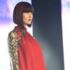 A woman in a red dress with a sharp purple lob cut