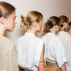 A line of Aveda models, dressed in white