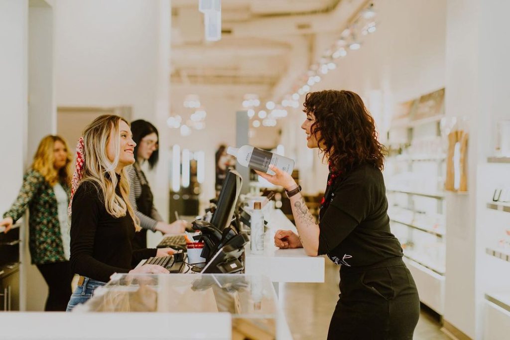 Woman chatting with salon owners over counter